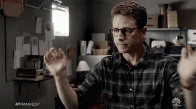 Man In Glasses And Plaid Shirt In Front Of NBC Logo GIF