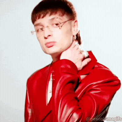 Man In Glasses And Red Jacket Looking At Camera GIF
