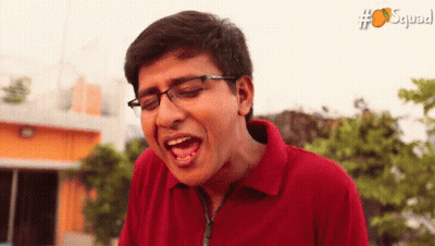Man In Glasses And Red Shirt Making Funny Face With Squad GIF