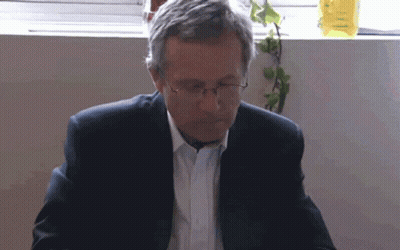 Man In Glasses And Suit Looking Down GIF