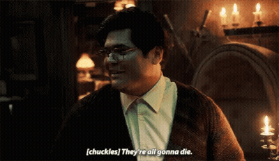 Man In Glasses And Sweater Talking In Dark Room GIF