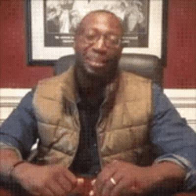 Man In Glasses And Vest At Desk GIF