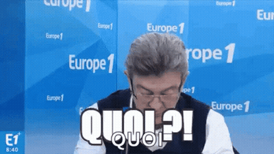 Man In Glasses And Vest Sitting In Front Of Europe 1 Wall GIF