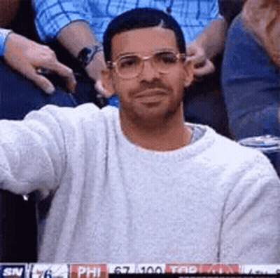Man In Glasses And White Sweater Sitting In Stands GIF
