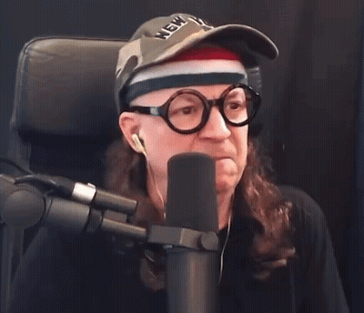 Man In Glasses And York Hat Says Boo Into Microphone GIF