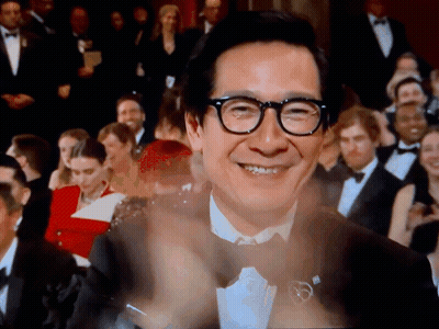 Man in Glasses Clapping Before Crowd