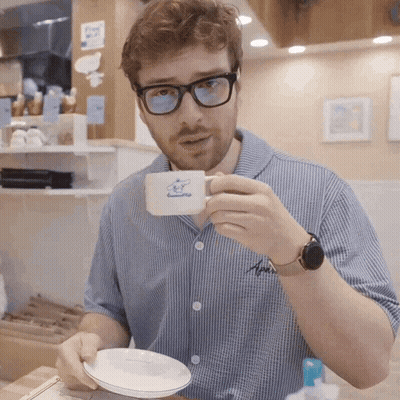 Man In Glasses Holding Coffee Cup With Sheep GIF