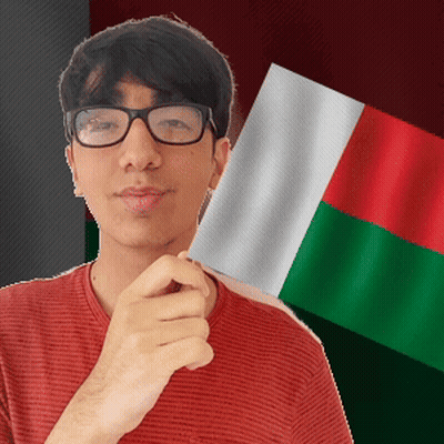 Man In Glasses Holding Flag In Front Of Green And Red Flag GIF