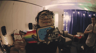 Man In Glasses Holding Rainbow Cat Toy GIF