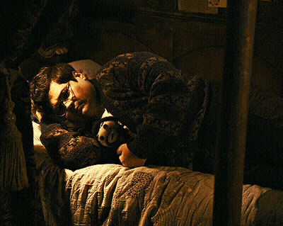 Man In Glasses Lying On Bed With Stuffed Animal GIF