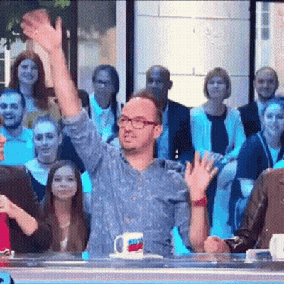 Man In Glasses Waving At Crowd GIF