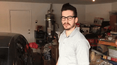Man In Glasses With 6 Gallon Box In Garage GIF