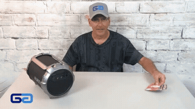 Man In Go Hat Sitting At Table Next To Boombox GIF