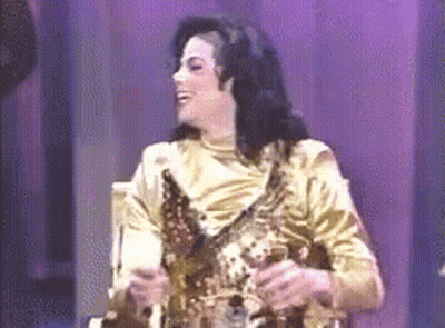 Man In Gold Dress Holding Trophy On Stage GIF