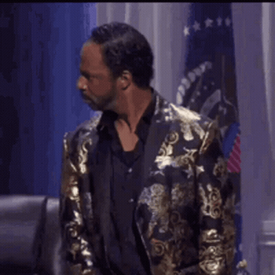 Man In Gold Jacket And Black Shirt GIF