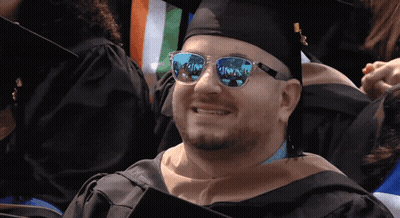 Man In Graduation Cap And Gown With Sunglasses Reflecting Paradise GIF