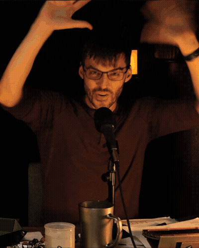 Man In Gray Shirt Held By Another Man's Hand GIF