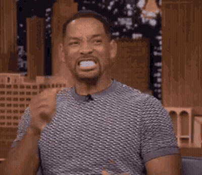 Man In Gray Shirt Making Funny Face At Table GIF