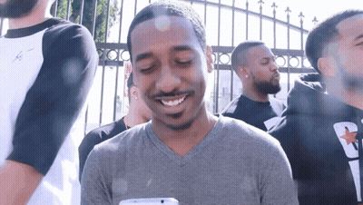 Man In Gray Shirt Smiling At Phone GIF