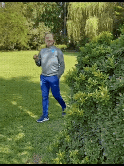 Man In Gray Sweatshirt And Blue Pants Standing In Park GIF