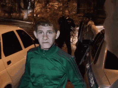 Man In Green Adidas Jacket Standing In Front Of Car GIF
