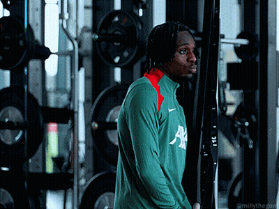 Man In Green Allianz Shirt In Front Of Gym Machine GIF