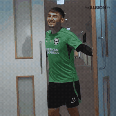 Man In Green American Express Jersey Standing In Hallway GIF