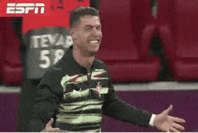 Man In Green And Black Shirt Smiling In Stadium GIF