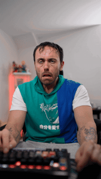 Man In Green And Blue Shirt With Chinese Writing GIF