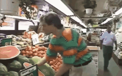 Man In Green And Orange Shirt Looking At Watermelons GIF