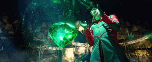 Man in Green and Red Coat Holding Green Cube