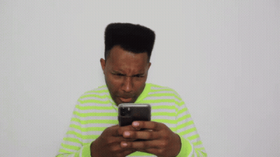Man In Green And White Striped Shirt Looking At Cell Phone GIF