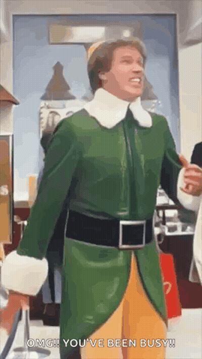Man In Green And Yellow Elf Costume Standing In Store GIF