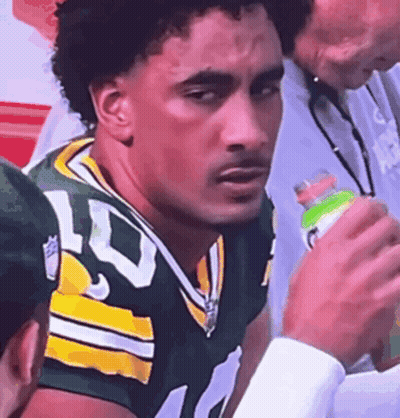 Man In Green And Yellow Football Uniform Holding Gatorade Bottle GIF