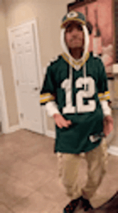 Man In Green Bay Packers Jersey Standing In Room GIF