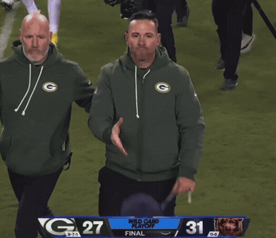 Man In Green Bay Packers Sweatshirt Next To Bears Jersey GIF