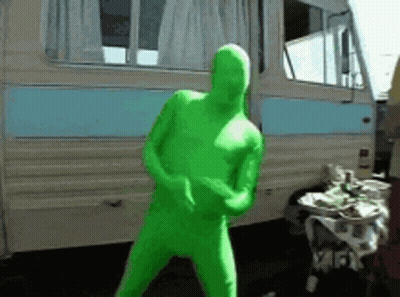 Man In Green Bodysuit Dancing By Camper Van GIF