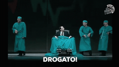 Man In Green Cloth Chair On Stage With Surgical Gowns GIF