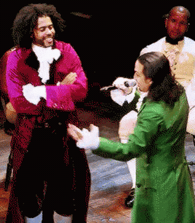 Man In Green Coat Singing Into Microphone With Man In Red Coat GIF