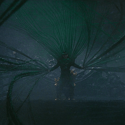 Man In Green Costume Surrounded By Green Wires GIF