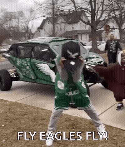 Man In Green Eagles Jersey Holding Baseball Cap In Front Of Green Vehicle GIF