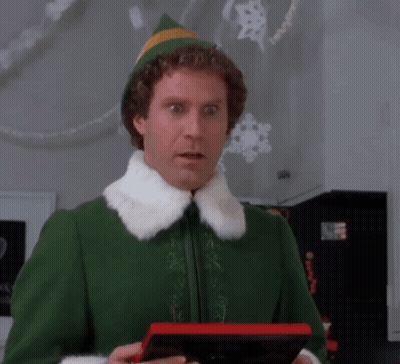Man In Green Elf Costume Surprised With Red Box GIF