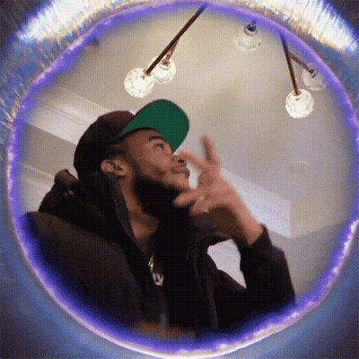 Man In Green Hat And Black Jacket Looking Up GIF