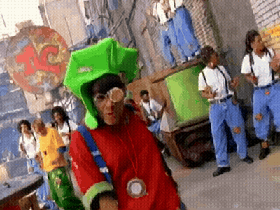 Man In Green Hat And Glasses In Front Of Group In Blue Jeans And Suspenders GIF