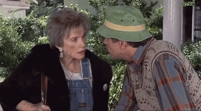 Man In Green Hat Kissing Woman On Cheek GIF