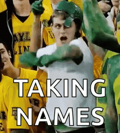 Man In Green Helmet Taking Names In Front Of Crowd GIF