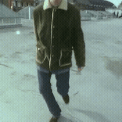 Man In Green Jacket And Blue Jeans On Rooftop GIF