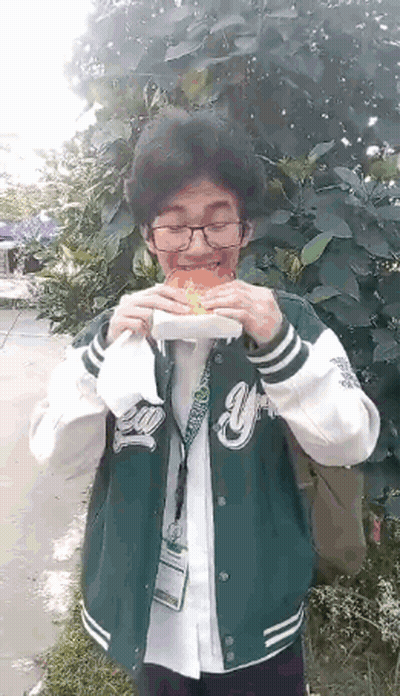 Man In Green Jacket Eating Hamburger GIF