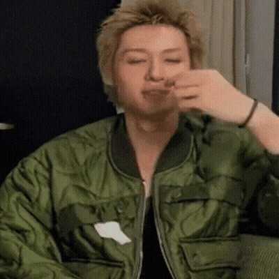 Man In Green Jacket Eating On Couch GIF