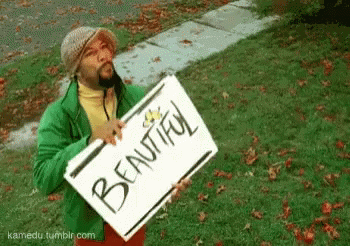 Man In Green Jacket Holding Beautiful Sign GIF